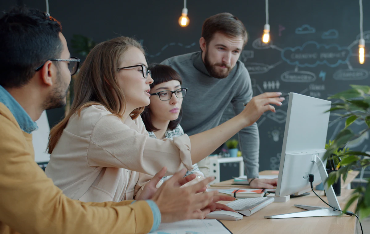 Equipe do departamento pessoal trabalhando junta em frente ao computador